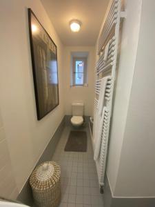 a bathroom with a toilet and white towels at Apartments by DASBREITEHOTEL in Basel +14 photos