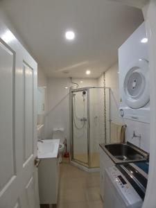 a white bathroom with a shower and a sink at New Door Apartments in Nadi