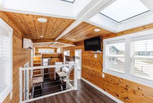 Harrington Tiny House في Apple Valley: غرفة بجدران خشبية ونور علوي