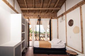 a bedroom with a bed and a window at Guaduas de Jade Casa campestre in La Mesa