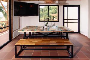 a dining room with a table and a bench at Guaduas de Jade Casa campestre in La Mesa