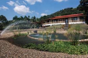 a house with a fountain in front of a garden at Guaduas de Jade Casa campestre in La Mesa