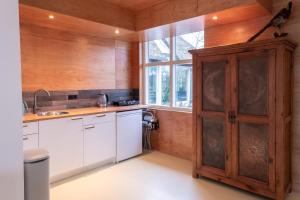 a kitchen with white cabinets and a wooden door at Dream apartments in Hoogwoud