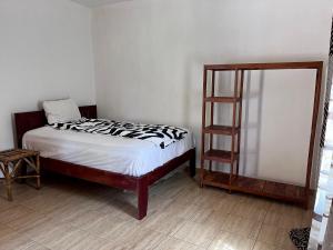 a small bedroom with a bed and a book shelf at Amas Bungalow with internett in Batukunku
