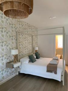 a bedroom with a large white bed with green pillows at Verdolivo in Sale Marasino +82 photos