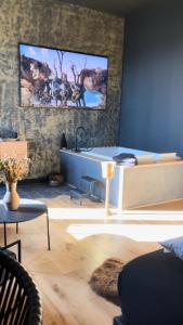 sala de estar con lavamanos y TV en la pared en Mas Escala Suites & Spa, en Istres