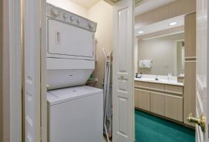ein Badezimmer mit einer Waschmaschine, einem Trockner und einem Spiegel in der Unterkunft Gorgeous Condos at Thousand Hills - Heart of Branson - Spacious and Affordable in Branson