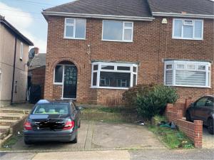 een auto geparkeerd voor een bakstenen huis bij Contractor & Family Friendly House Romford in Havering atte Bower