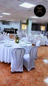 a banquet hall with white tables and white chairs at Hotel y Restaurante Costas in Fortuna