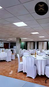 a banquet hall with white tables and white chairs at Hotel y Restaurante Costas in Fortuna