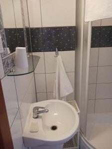 a small bathroom with a sink and a shower at Pokoje Gościnne Jana in Łeba