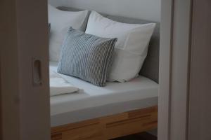 a white bed with two pillows on it at Neubau2024 - Ferienwohnung Ott in Halblech