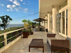 Hotel Marambaia Cabeçudas - frente mar في إيتاجاي: فناء مع كراسي وطاولات والمحيط