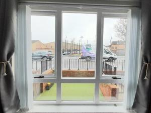 een raam met drie uitzicht op een parkeerplaats bij 293 Holiday Home in Belfast