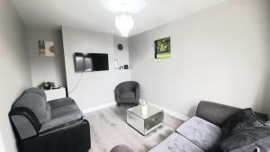 a living room with a couch and a chair at 293 Holiday Home in Belfast