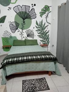 ein Schlafzimmer mit einem Bett und einer Wand mit Pflanzen in der Unterkunft Calli Cintli in Tepoztlán
