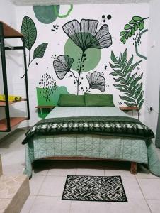 ein Schlafzimmer mit einem Bett mit einer Wand mit Pflanzen in der Unterkunft Calli Cintli in Tepoztlán