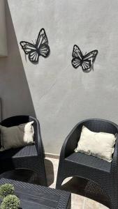trois papillons noirs sur un mur avec deux chaises dans l'établissement Departamento Carosini. Amplio familiar., à Concepción del Uruguay