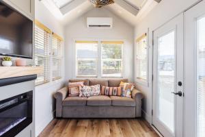 ein Wohnzimmer mit einem Sofa und Fenstern in der Unterkunft Sun Catcher in Apple Valley