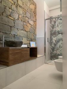uma casa de banho com uma parede de pedra e um chuveiro em VistaMare & Relax Cinque Terre SeaView & Relax Cinque Terre em Vernazza