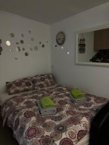 1 dormitorio con 1 cama con toallas verdes en Nilton 2 Apartmans en Niš