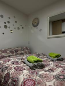 Una cama con dos almohadas verdes encima. en Nilton 2 Apartmans en Niš