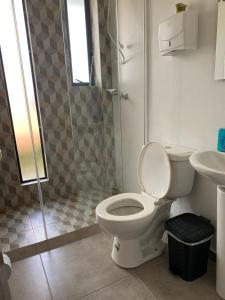 y baño con aseo y ducha. en Caminos del dorado sede apartamento, en Guatavita