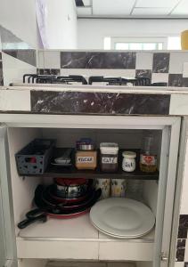 un armario lleno de platos y sartenes en la cocina en Acogedor Apartaestudio cerca al aeropuerto, en Cúcuta