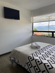 a bedroom with a bed with two towels on it at Caminos del dorado sede apartamento in Guatavita