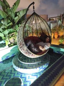 une femme dort dans un panier suspendu dans une piscine dans l'établissement Riad Marhaba, à Rabat