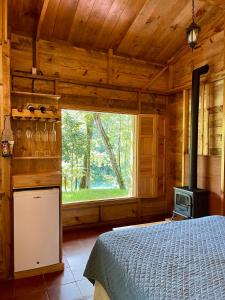 1 dormitorio con 1 cama y estufa en una cabaña en Hotel en Finca Chijul, reserva natural privada en San Juan Chamelco