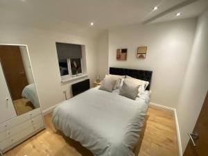 een witte slaapkamer met een bed en een spiegel bij Manvers house city centre in Nottingham