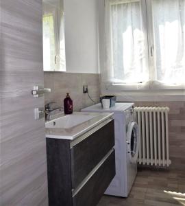 a kitchen with a sink and a washing machine at Green House Mountain Lake Iseo Hospitality in Bossico