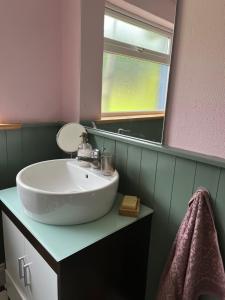 y baño con lavabo y espejo. en Reenard South seaview country cottage en Cahersiveen