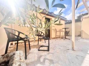 a patio with chairs and tables in front of a building at Appartement Esprit Industriel in Gentilly