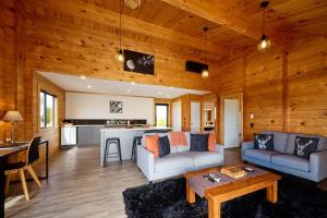 a living room with a couch and a table at Deerbrooke Kaikōura Chalets - Chalet 1 in Kaikoura