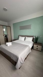 a large bedroom with a large bed with white sheets at Chris Holiday in Oradea