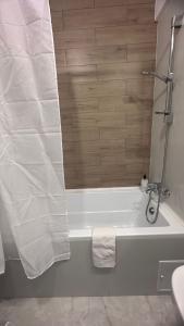 a white bath tub with a shower curtain in a bathroom at Chris Holiday in Oradea +45 photos