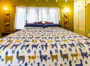 a bedroom with a bed with a blue and white quilt at Beach House In Crown Point- walk to the beach in Bon Accord