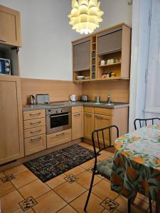 ブダペストにあるDanube Bridge Apartmentsのキッチン(木製キャビネット、テーブル、シャンデリア付)