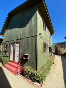 un granero verde con una puerta roja y una ventana en Lilafken Apart Pichilemu, en Pichilemu 37 fotos más