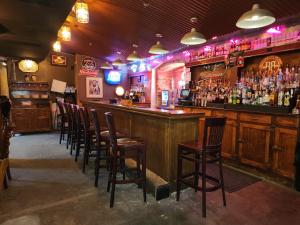 um bar com uma fila de cadeiras num bar em Historic Iron Horse Inn - Deadwood em Deadwood