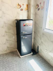 um frigorífico velho num canto de um quarto em Résidence Mounir em Thiès