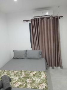 a bed in a room with a window with a curtain at Pacific Apartment in Suva