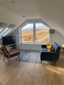 a living room with a couch and a large window at Urgha Bay in Tarbert