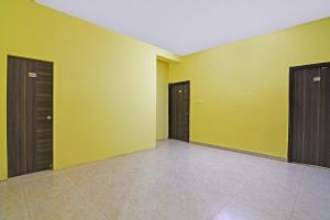 a empty room with yellow walls and brown doors at OYO Flagship Samrudhi Residency in Jānla