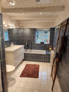 a bathroom with a tub and a toilet and a sink at Charmerende stråtag strå hus (med Vildmarksbad) in Give +16 photos