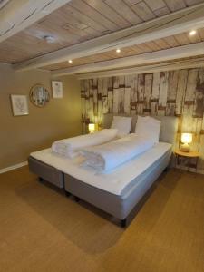 a bedroom with a large bed in a room at Charmerende stråtag strå hus (med Vildmarksbad) in Give