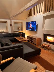 a living room with a couch and a fireplace at Charmerende stråtag strå hus (med Vildmarksbad) in Give