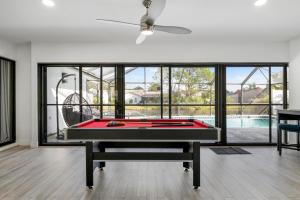 un tavolo da biliardo nel mezzo di un soggiorno con piscina di Tropical Tranquility! Luxury pool home with lakefront view just minutes from the beach! a Bradenton